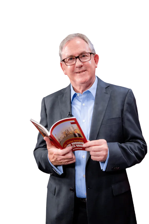 David Thomas holding an open copy of his book, cut out on a transparent ground