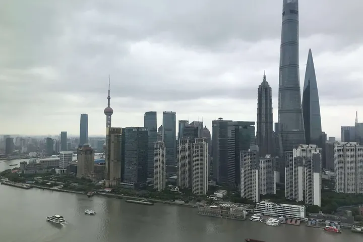 Shanghai's Lujiazui towers rising over the river on an overcast day