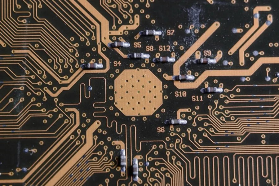 A printed circuit board in close-up, its copper tracks fanning out across the board